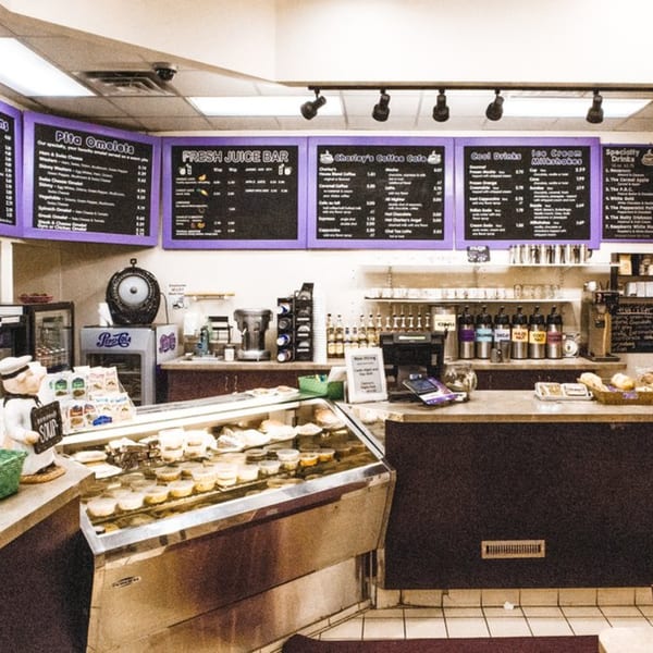 Interior of Charley's Deli and Grille, showing a deli counter, drink station, and menu boards.