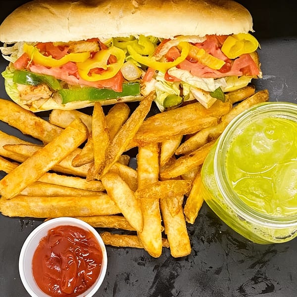 A Charley's Deli and Grille sub sandwich with fries, ketchup, and a green drink.