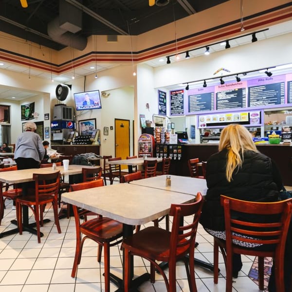 Interior of Charley's Deli and Grille with customers seated at tables and a counter in the background.